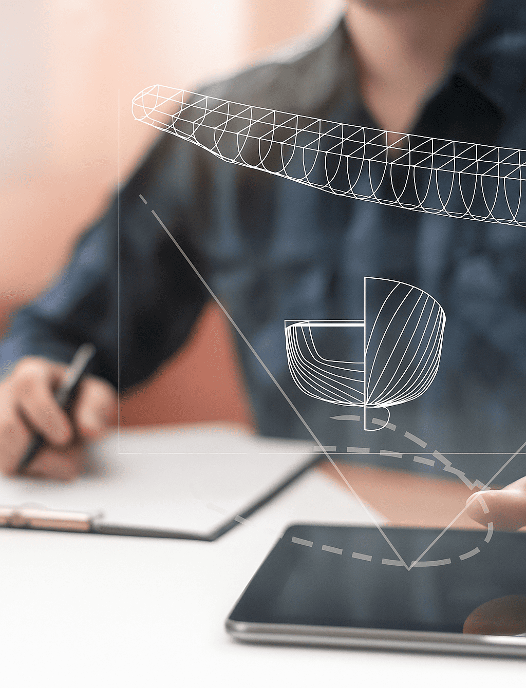 An engineer working on a marine design project with digital overlays of a ship's hull.